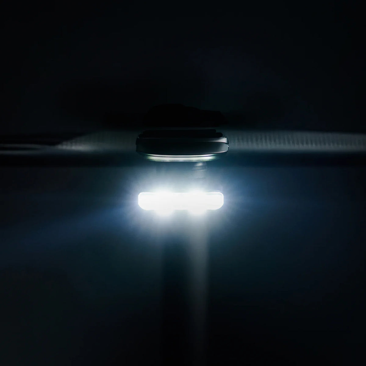 Lezyne Road Drive 500 bike light illuminating in a dark environment, showcasing its powerful LED feature.