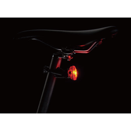 CatEye Omni 3 rear light mounted on a bicycle seat post, showcasing its bright LED visibility.