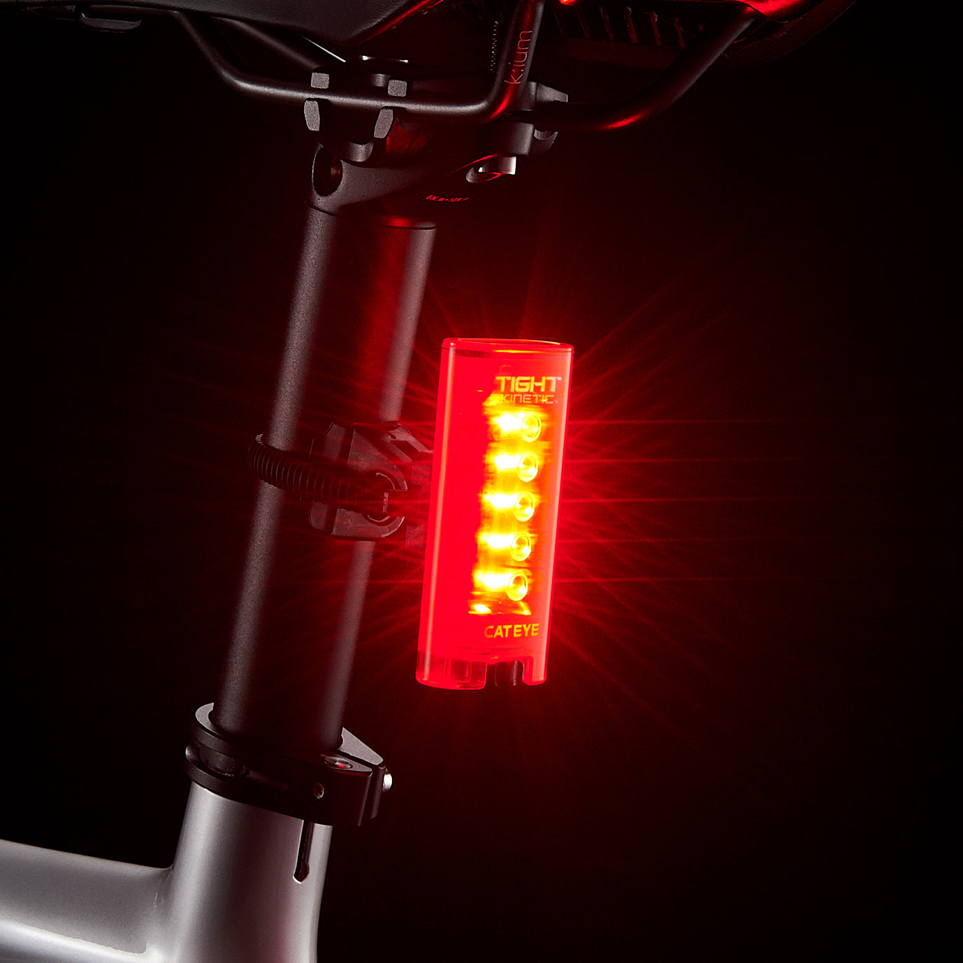 CatEye kinetic rear bike light mounted on a bike seat post, showcasing its bright red LED lights for safety.