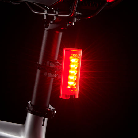 CatEye kinetic rear bike light mounted on a bike seat post, showcasing its bright red LED lights for safety.