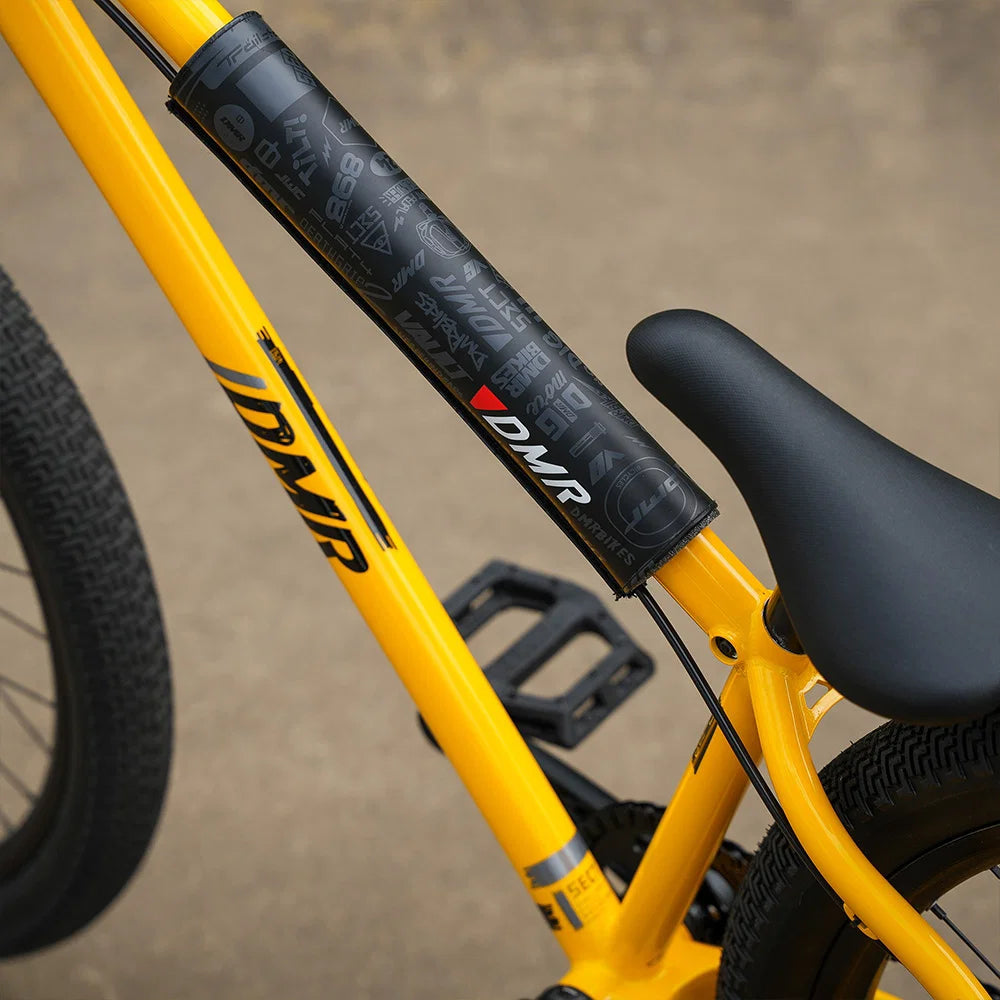 DMR BMX bike frame pad on a yellow BMX bike for protection and style.