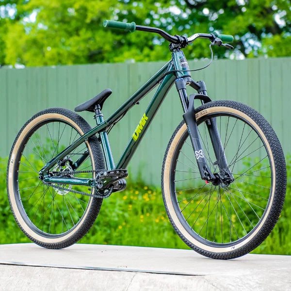 DMR Moto DJ jump dirt track tyre mounted on a stylish mountain bike in outdoor setting.
