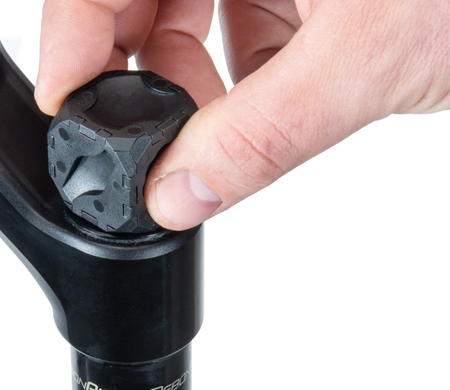 User demonstrating the Park Tool FCT-1 suspension fork cap removal tool for easy cap removal.