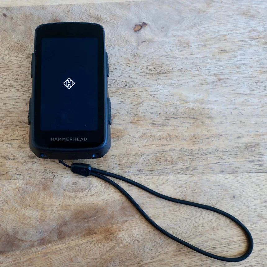 Hammerhead Karoo safety lanyard attached to Hammerhead device on wooden surface.