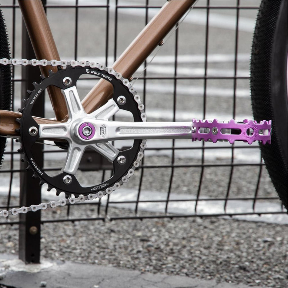 MKS XC-III Bear Trap flat pedals on a BMX bike crankset with a purple pedal and silver chainring.