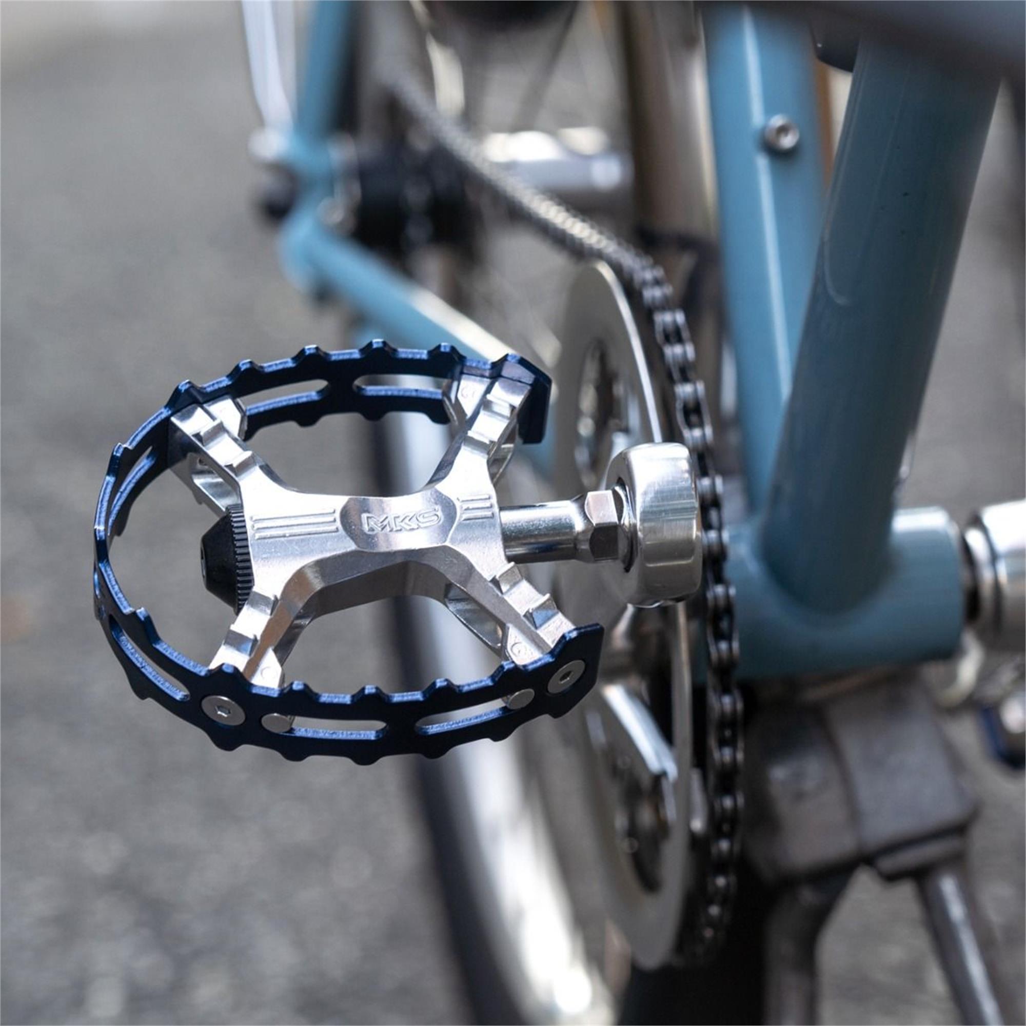MKS XC-III Bear Trap flat pedals installed on a blue bicycle, showcasing a durable and stylish design.