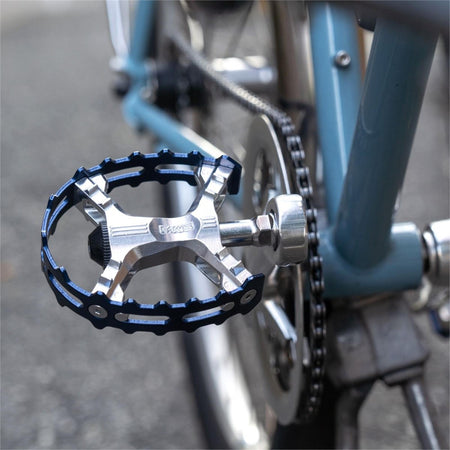 MKS XC-III Bear Trap flat pedals installed on a blue bicycle, showcasing a durable and stylish design.