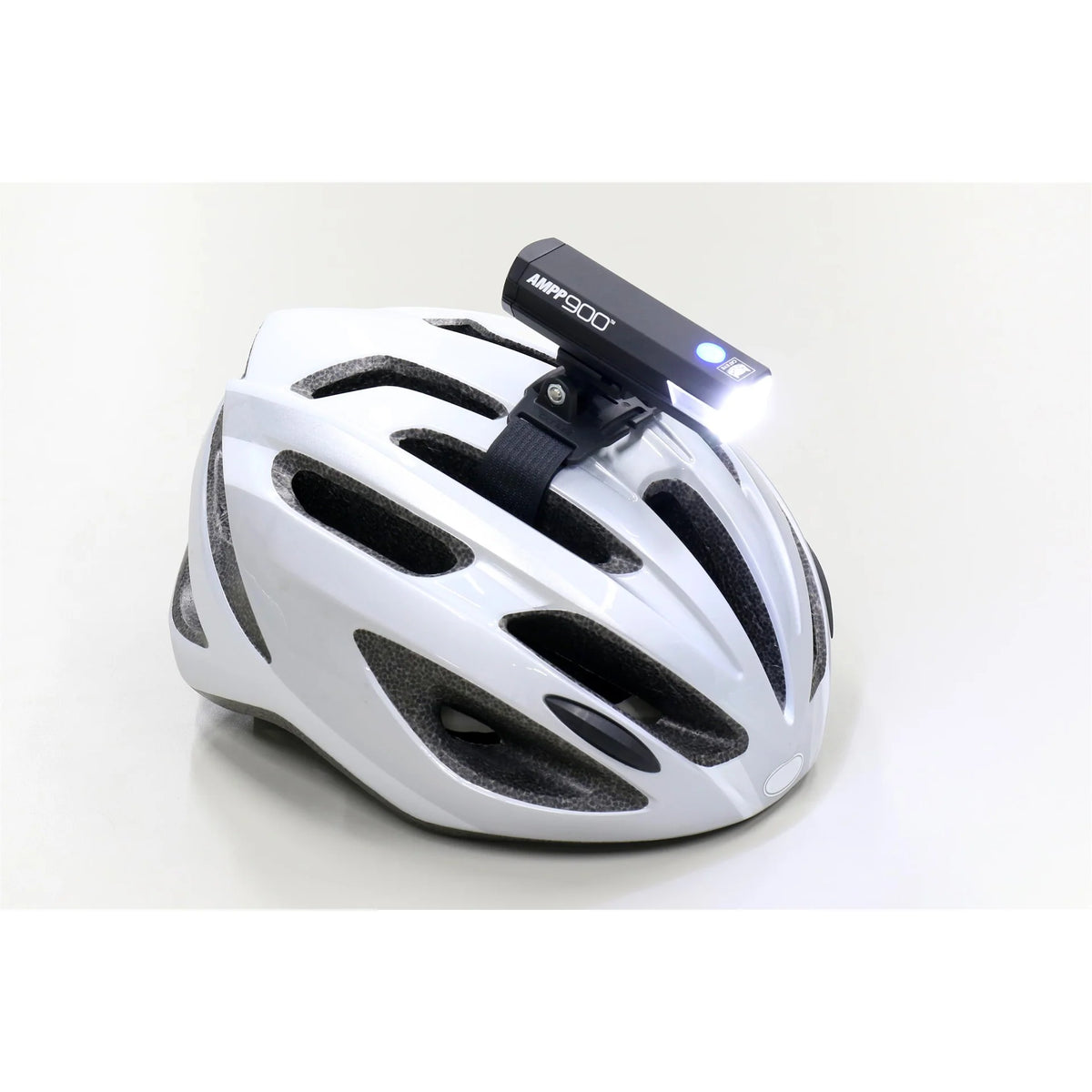 CatEye AMPP 900 bicycle light mounted on a white bicycle helmet for enhanced visibility and safety.