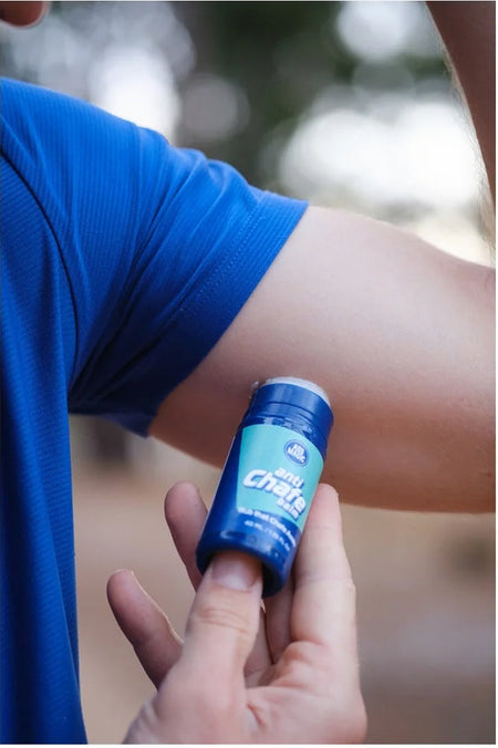 Applying Ass Magic anti chafe balm for athletes on arm before workout.