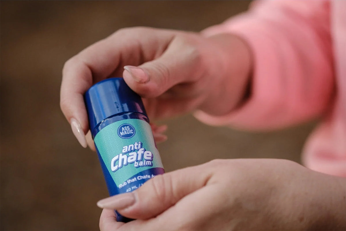 Hand holding Ass Magic anti chafe balm, ideal for chafing prevention with anti chafe balm for athletes.