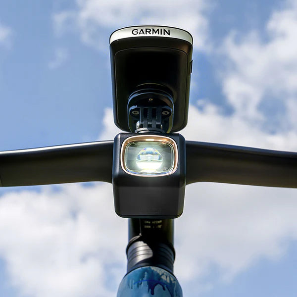 Ravemen UR1700 1700 lumens rechargeable bike light mounted on bike handlebars against a blue sky.