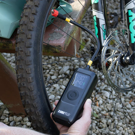 Electron Max Electric Pump for bikes and scooters inflating a bicycle tyre with digital display.
