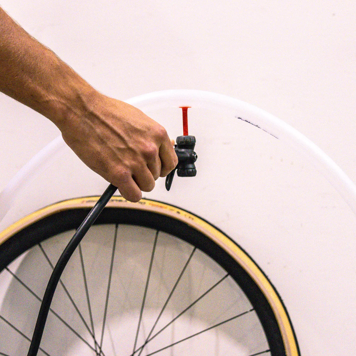 Hand using a pump to inflate a Vittoria ultra light speed inner tube with Presta valve.